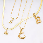 Einzelner Bamboo Bubble Buchstaben-Anhänger in glänzendem Gold – Vergoldeter Bubble Buchstaben Anhänger mit Bobby Kette auf weißem Hintergrund