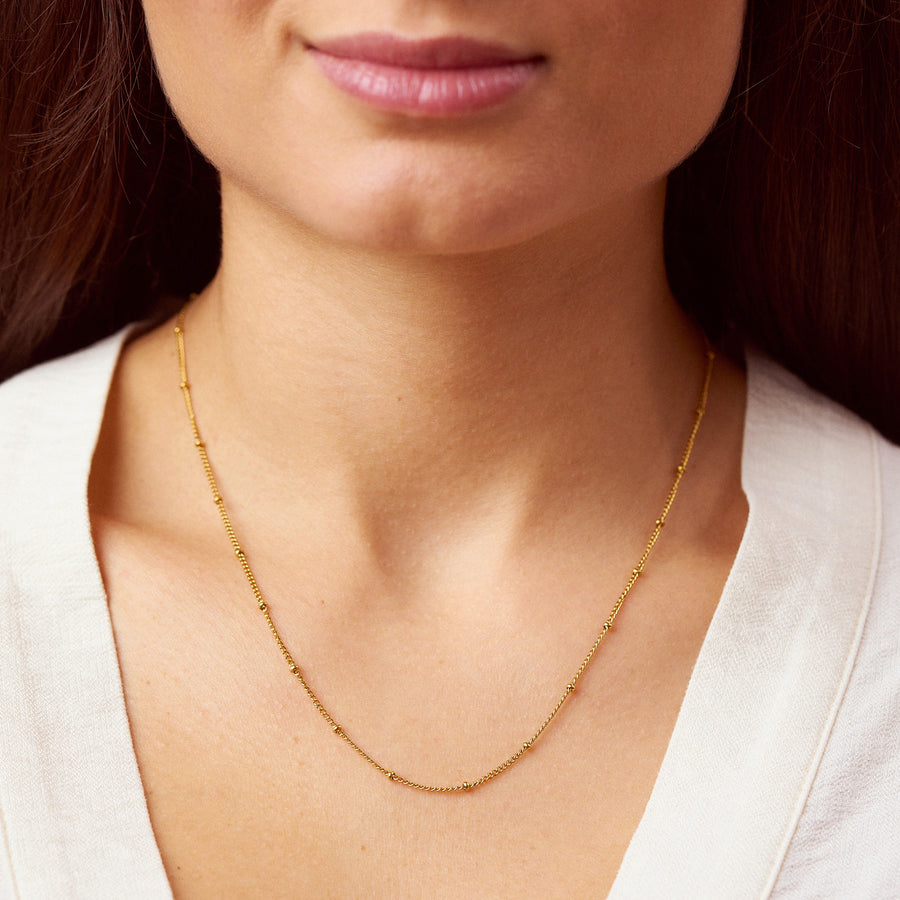Für diejenigen, die es filigran und unaufdringlich mögen, ist die Dot Halskette die perfekte Wahl! Die kleinen Kugeln sitzen fest und glitzern an deinem Hals. Sie lässt sich gut mit anderen Ketten kombinieren und auch mit einem Anhänger ist sie eine ideale Wahl. Eine Halskette für Frauen, 18k vergoldet und wasserfest.