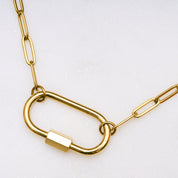 Goldene Gliederkette mit großem Karabinerverschluss, an dem ein herzförmiger Anhänger mit Perlenrand und ein kleiner Buchstabe „M“ hängen. Oben rechts steht in einem schwarzen Kasten: „Set Deal – 15 € off