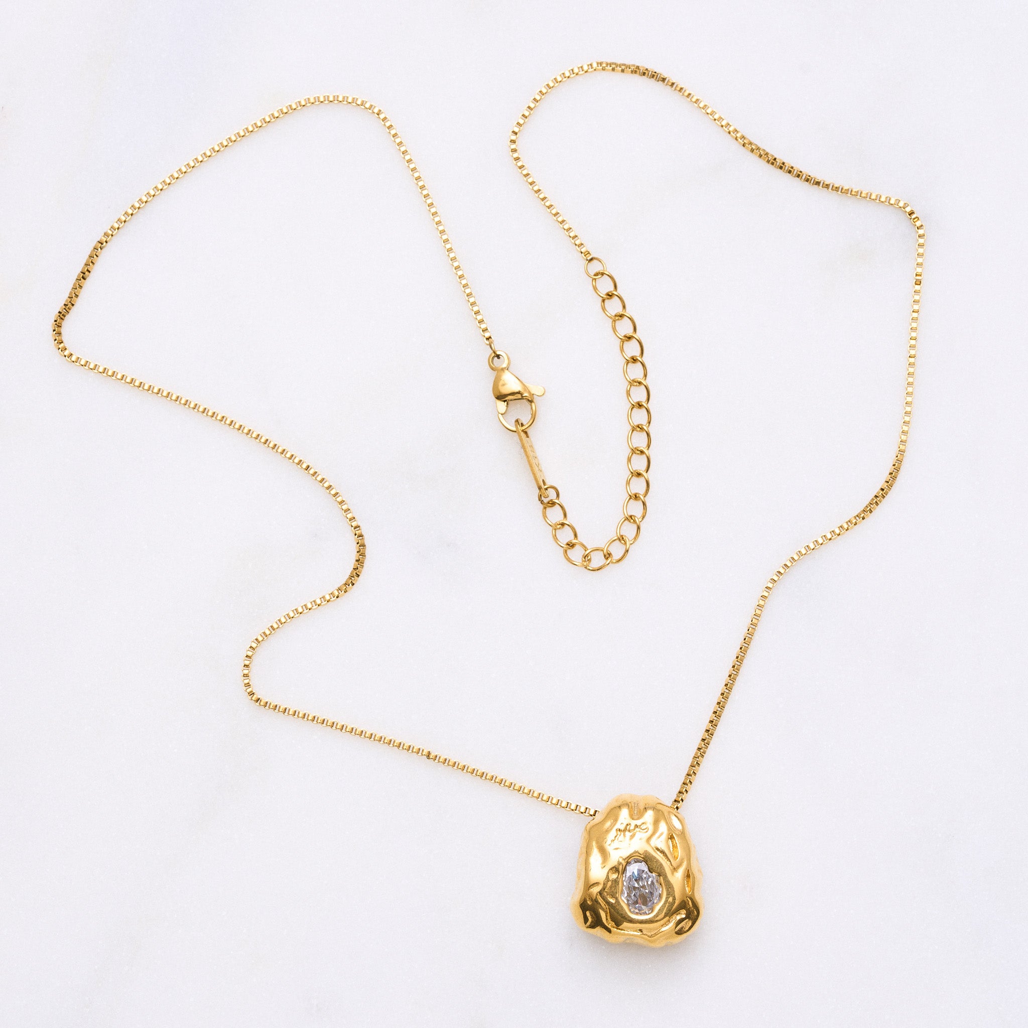 Ein Blickfang: Eine Kette mit einem organischen Anhänger, der mit einem funkelnden Zirkonia in der Mitte verziert ist. Der Anhänger symbolisiert die Schätze in den Bergen und erinnert daran, dass jeder seinen eigenen inneren Schatz hat. Die Kette ist ein Statement-Schmuckstück, das alleine für Aufmerksamkeit sorgt und in Kombination mit anderen Accessoires noch mehr Strahlkraft entfaltet.
