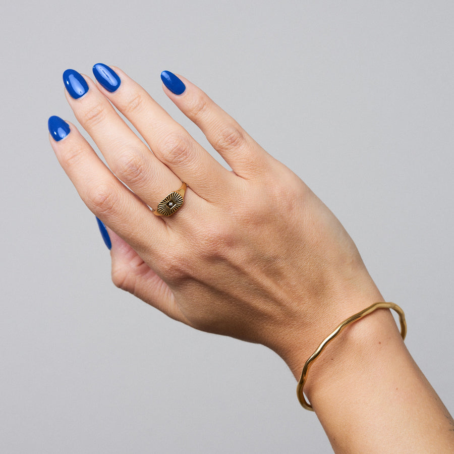Beam Ring: Filigraner Siegelring mit sonnenstrahlenartigen Einkerbungen und einem kleinen Glasstein in der Mitte. Ein dezentes Statement für Liebhaber
zarter Schmuckdesigns.